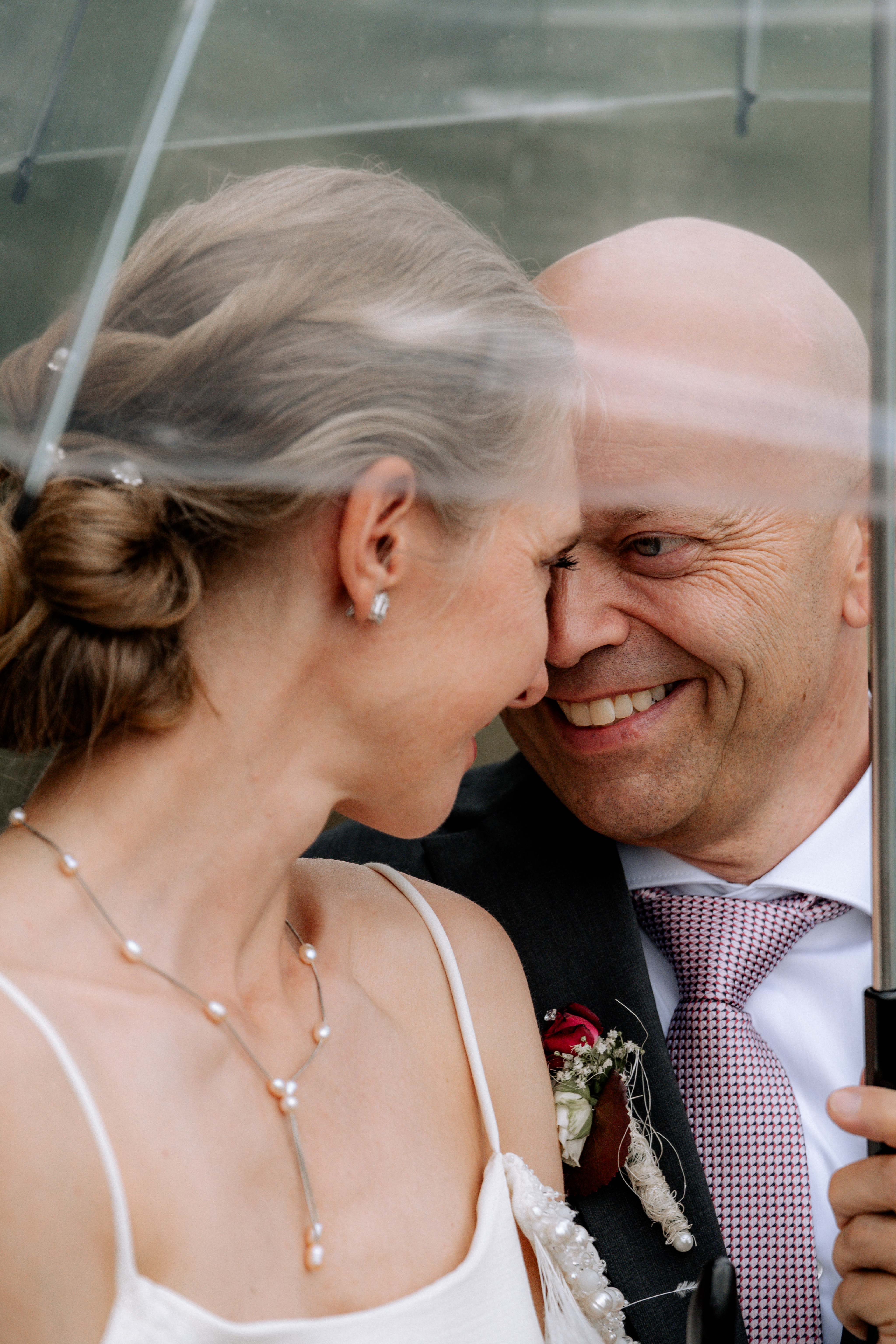 Lachendes Brautpaar unter Regenschirm – Hochzeitsfotografie im Thurgau - Hochzeitsfotograf Pablo aus Thurgau