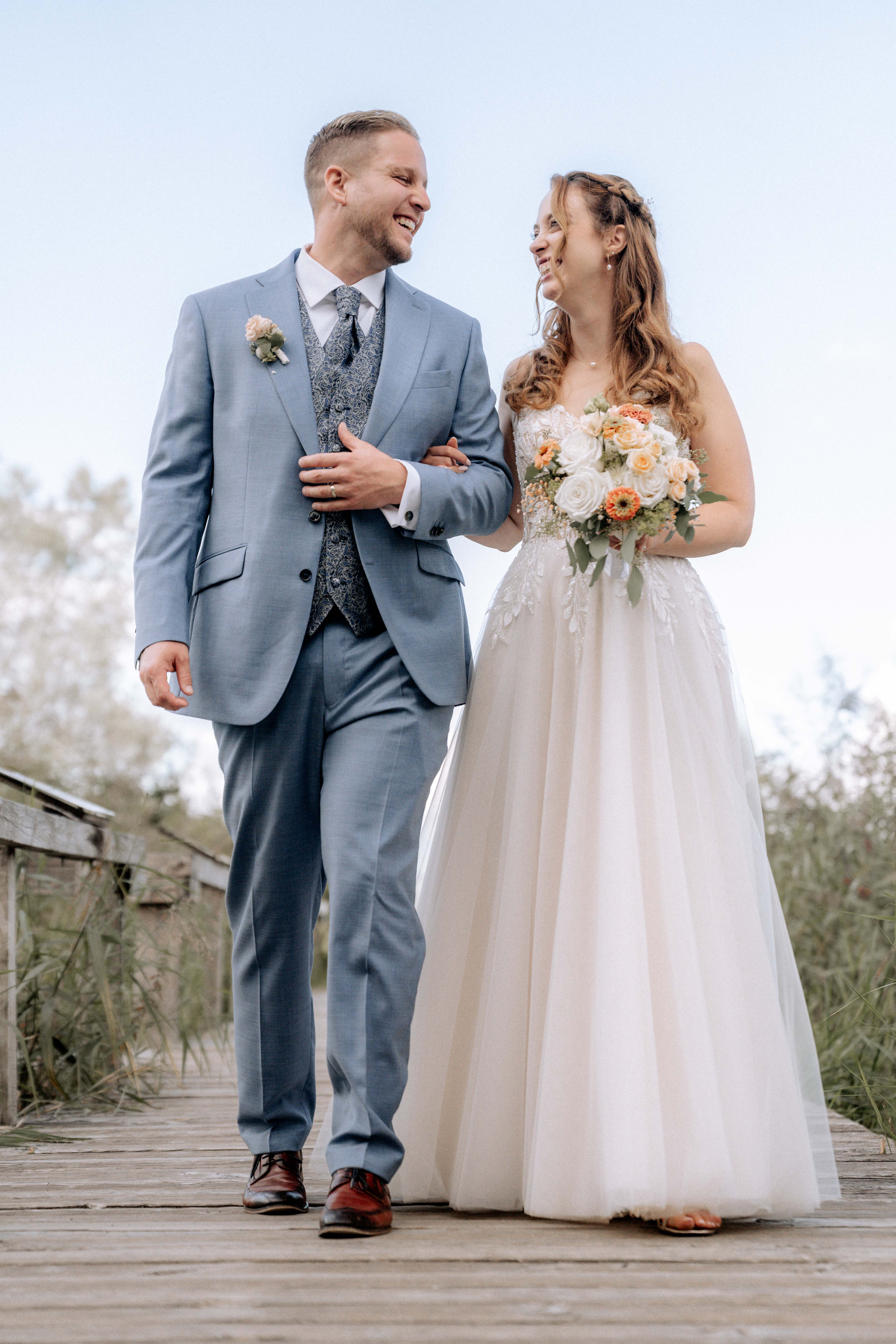 Glückliches Brautpaar spaziert auf Holzsteg – Hochzeitsfotografie - Hochzeitsfotograf Pablo aus Thurgau