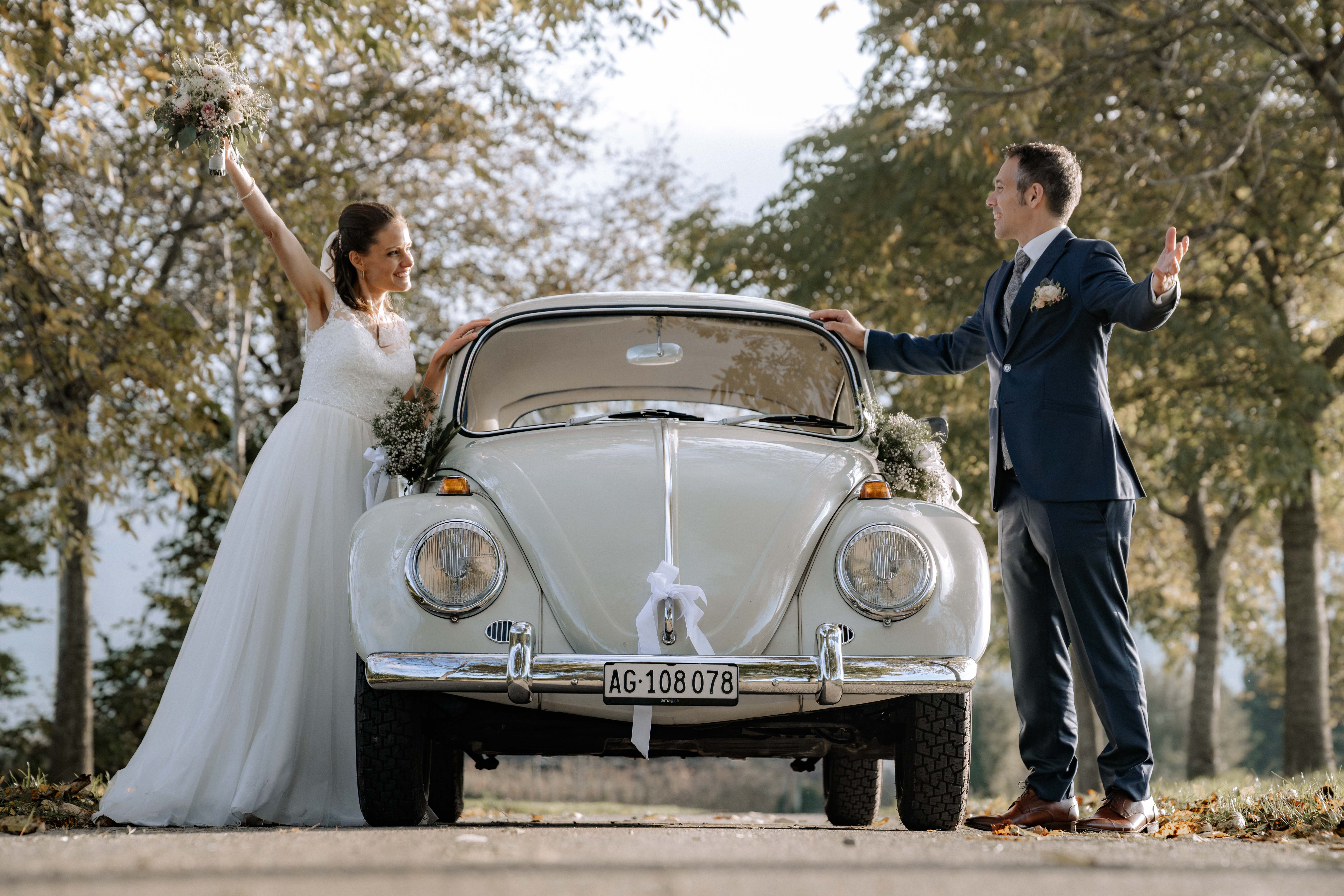 Brautpaar vor einem Oldtimer-Käfer mit Blumenschmuck, Hochzeitsfotografie Thurgau - Hochzeitsfotograf Pablo aus Thurgau