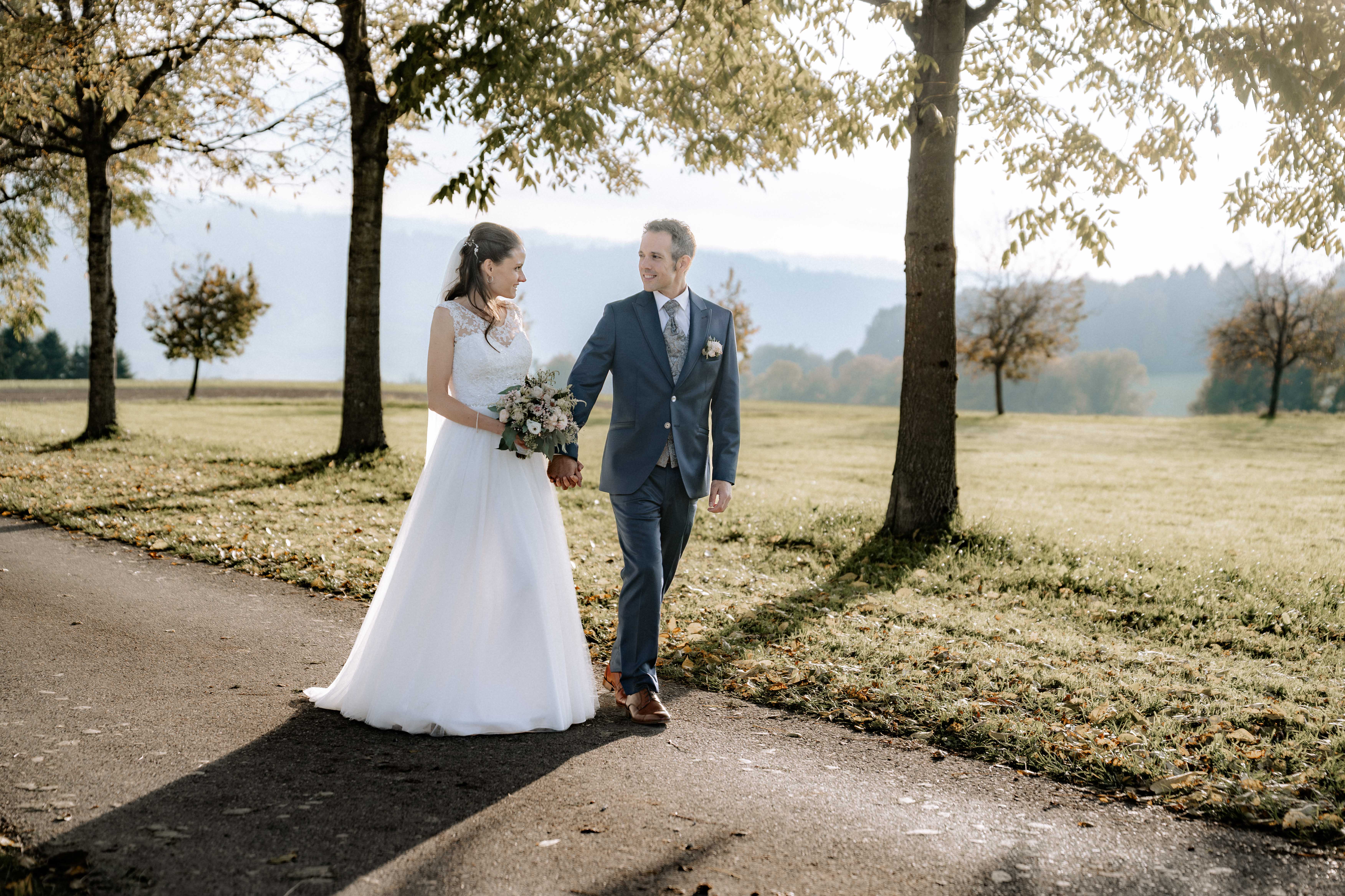Brautpaar spaziert Hand in Hand durch Herbstlandschaft im Thurgau - Hochzeitsfotograf Pablo aus Thurgau