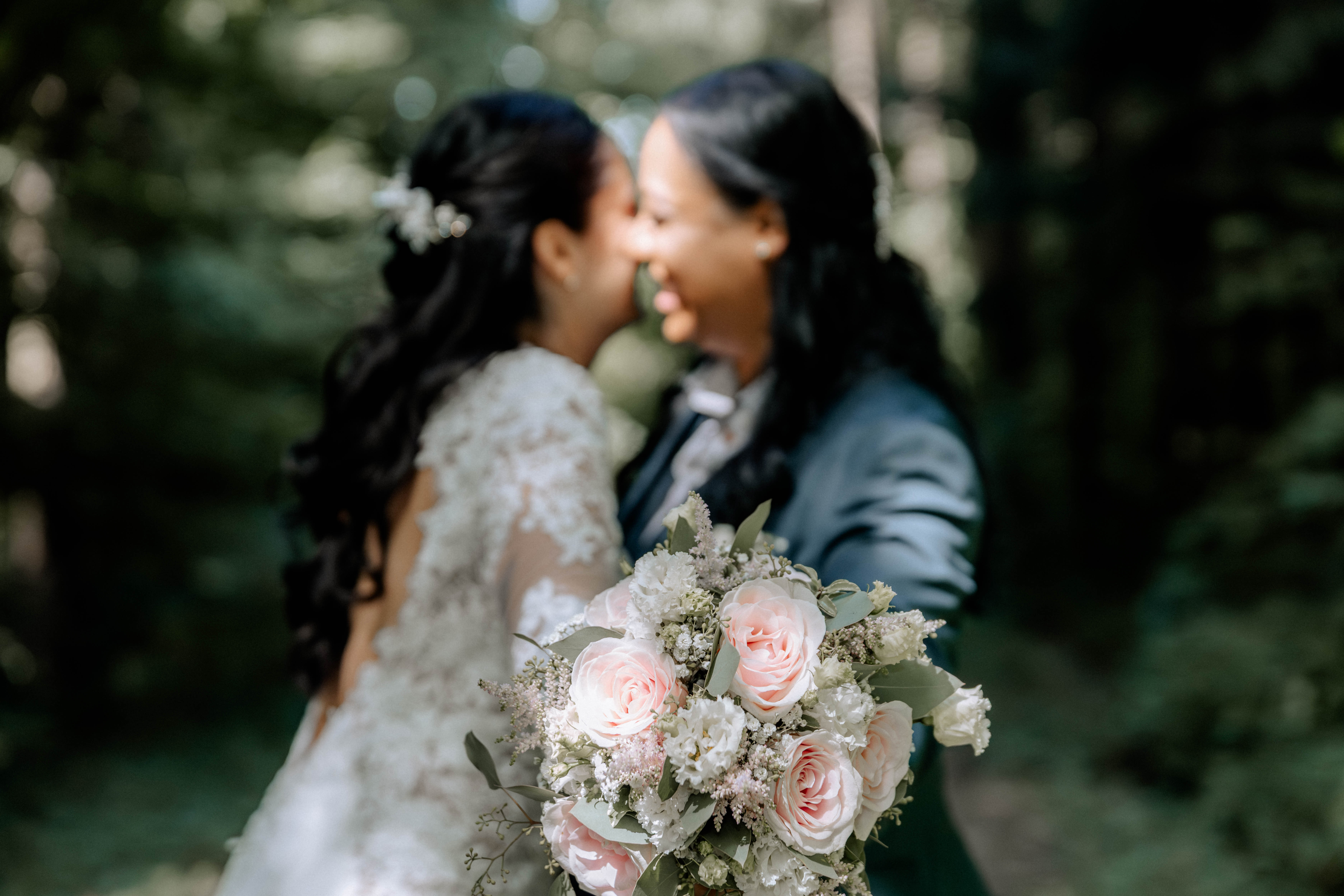 Hochzeitspaar küsst sich vor einem Blumenstrauß, Hochzeitsfotografie im Freien. - Hochzeitsfotograf Pablo aus Thurgau