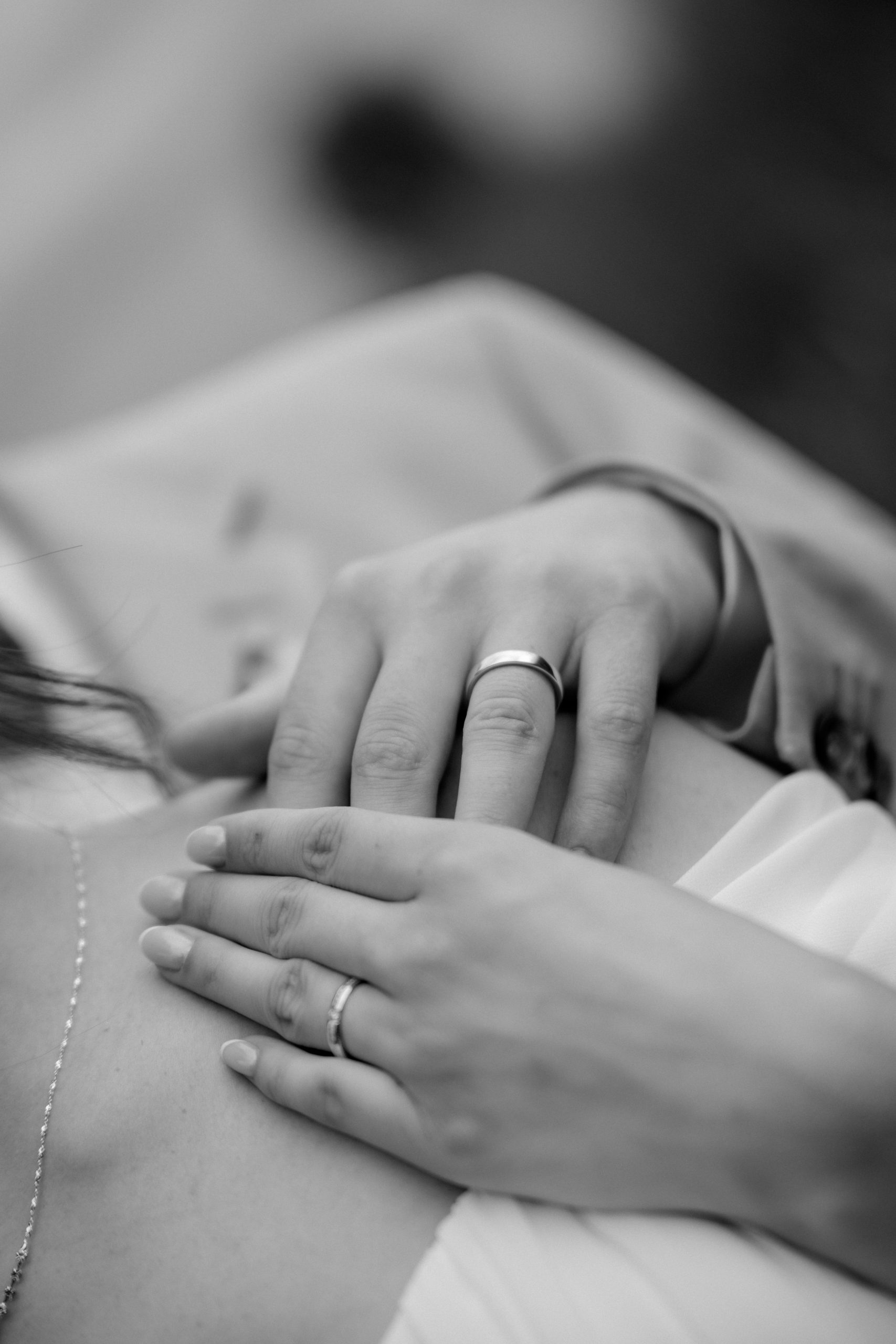 Nahaufnahme eines Brautpaares mit Eheringen, die Hände liegen zärtlich auf der Schulter und Brust. - Hochzeitsfotograf Pablo aus Thurgau